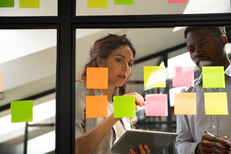 Two-people-strategic-planning-on-post-it-note